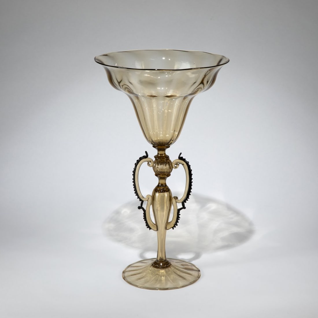 Vetreria Artistica Barovier & C., Goblet, c. 1920: <p>Model No. 15308. H, 43 cm. Straw-yellow glass, handles with deep purple flecks. Marked: Manufacturer's label (in French) numbered 15308, Brussels distributor's