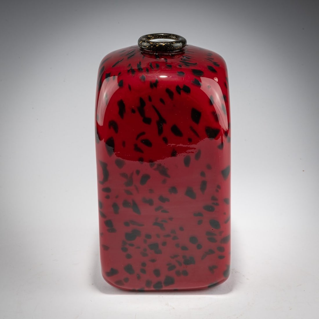 Fratelli Toso, 'Incamiciato rosso, granzioli e bordo nero' vase, c. 1932: <p>Tall cuboid with flattened shoulders. Model no. 8268. H. 26.5 cm. Cased glass, red with dark violet spots, white underlined, rim of dark violet glass with burst gold foil.
