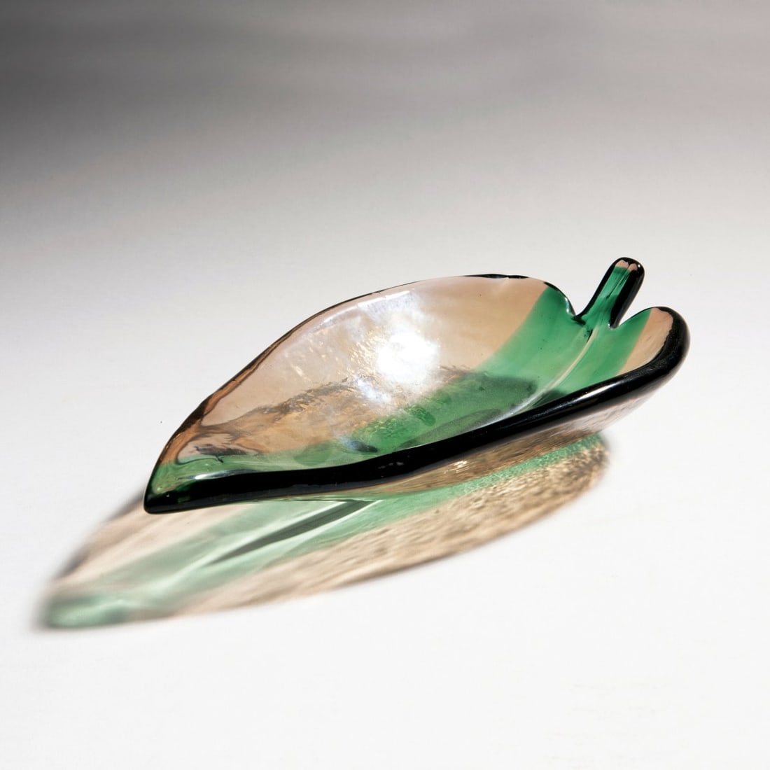 Tyra Lundgren, Bowl, c. 1935: <p>H. 7.3 cm; 31 x 18.3 cm. Execution: Venini. Cased glass, colorless and salmon-pink, fused green ribbon. Signed: venini murano (acid stamp).