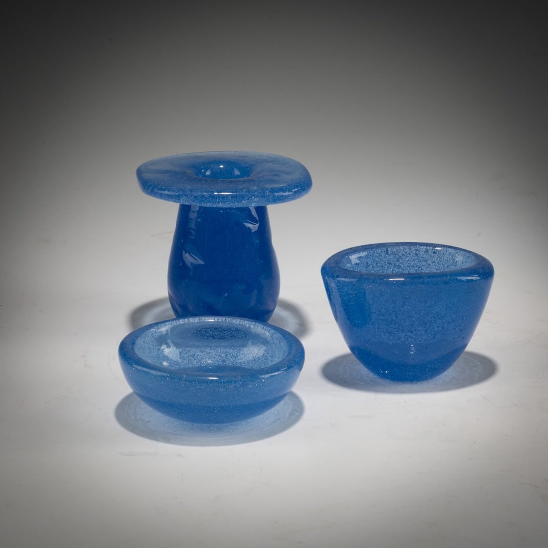 Carlo Scarpa, Candleholder and two 'Sommerso a bollicine' bowls, c. 1935: <p>H. 3&ndash;8.6 cm. Execution: Venini. Cased glass, colorless and light blue with air bubbles. Each marked on the base: venini murano (aicd stamp). </p>