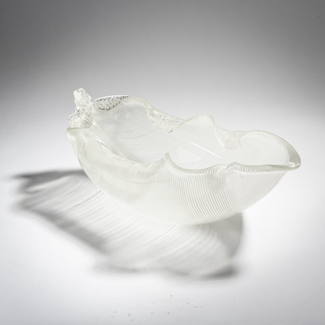Tyra Lundgren, 'Foglia' bowl, c. 1938: <p>H. 12 cm; L. 38 cm. Execution: Venini. Cased glass, colorless with included white thread. Signed on the bottom: venini murano (acid stamp).</p>