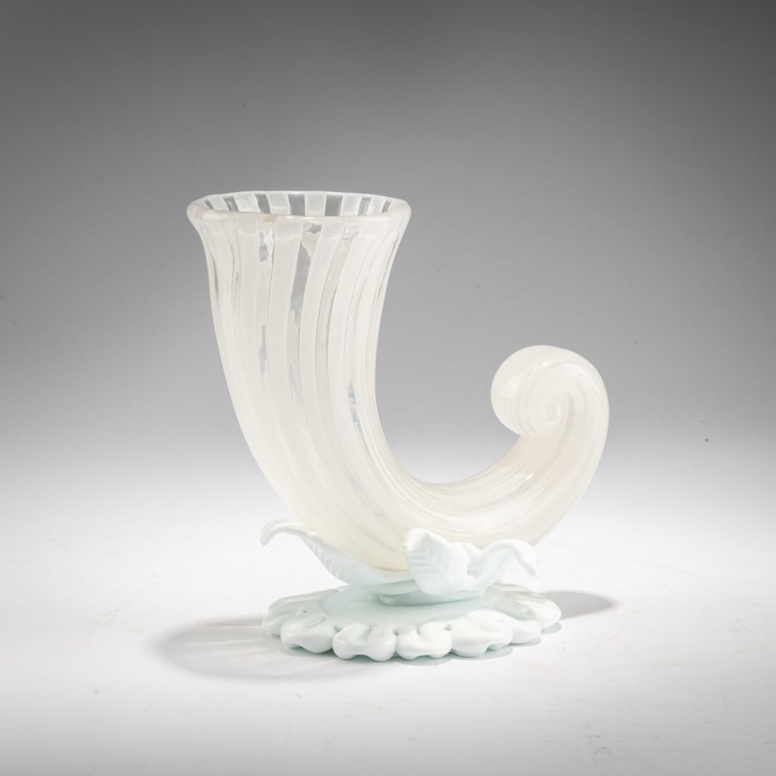 Fulvio Bianconi (1915 Padua - 1996 Milan), 'Cornucopia Zanfirico' vase, c. 1948-49: <p>Model No. 2979 (shape). H. 17.5 cm. Execution: Venini. cased glass, colorless with fused bands with a white (lattimo) thread pattern, base and leaf decoration in opaque white.