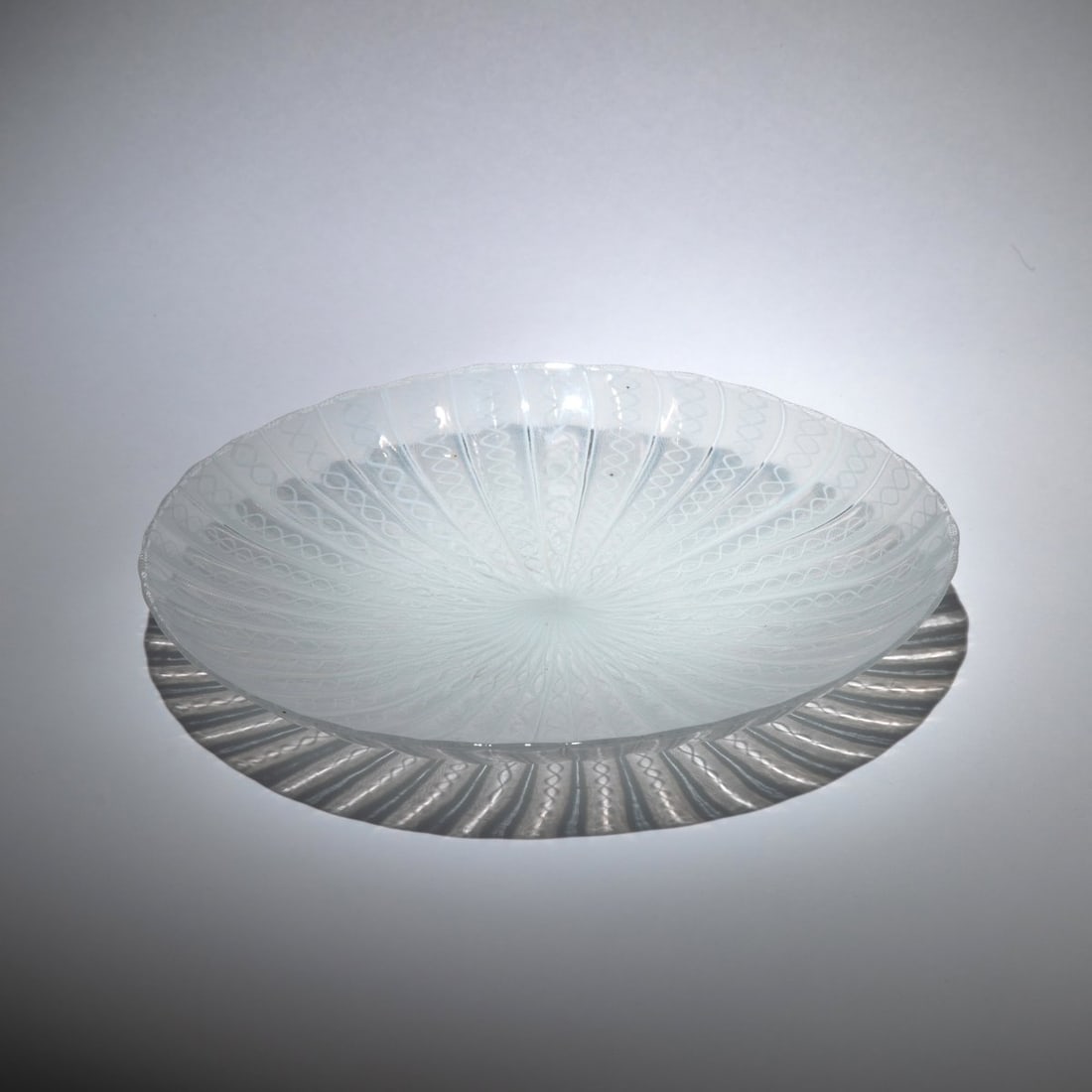 Paolo Venini, 'Filigrana' bowl, c. 1950: <p>H. 5.5 cm; 30.5 x 26 cm. Execution: Venini. Colorless glass with applied ribbons containing fused white mesh threads. Marked: venini murano ITALIA (acid stamp).</p>