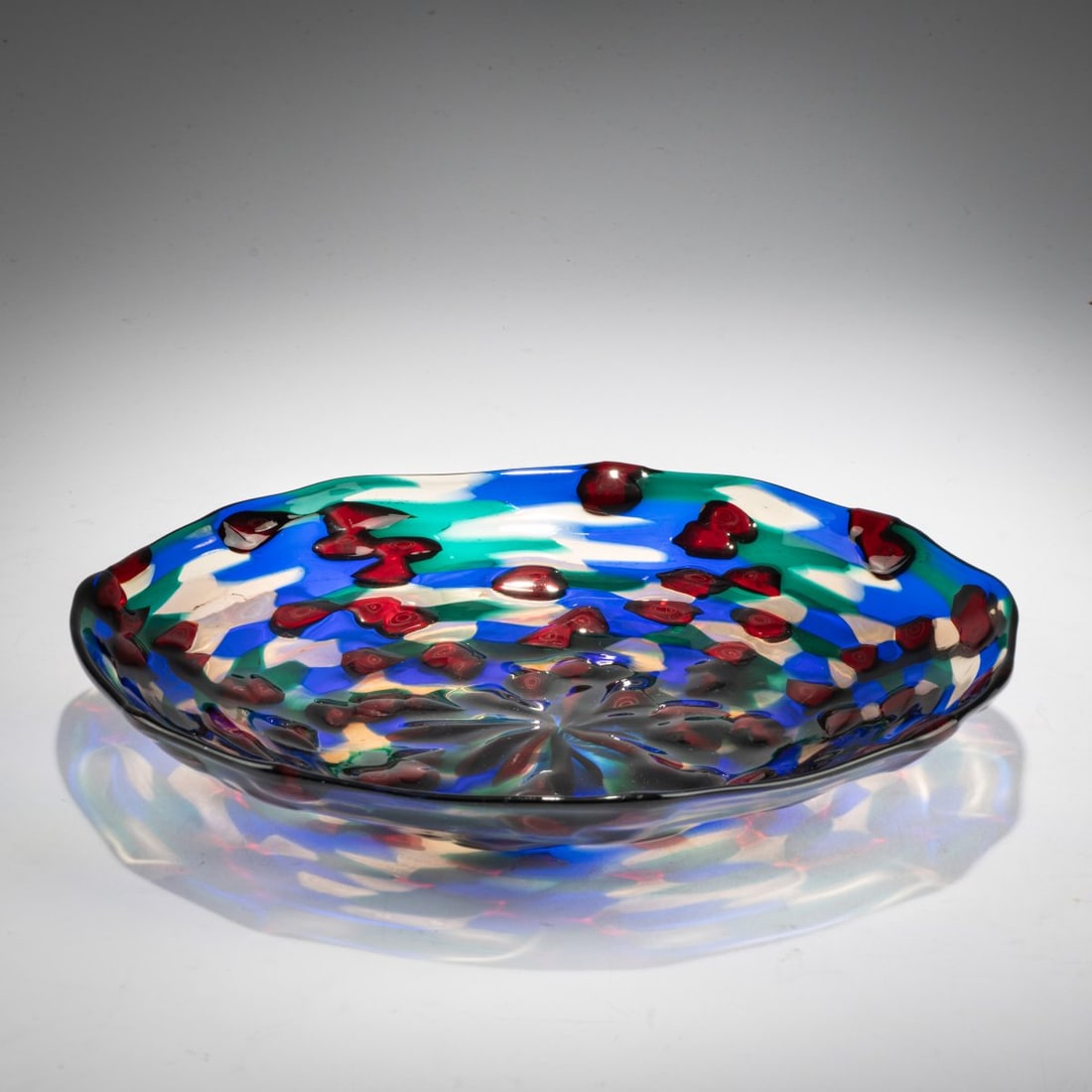 Fulvio Bianconi (1915 Padua - 1996 Milan), 'Murrine' plate, 1953-54: <p>&Oslash; 26.8 cm. Execution: Venini. Colorless glass with fused murrines in red, blue, green, and straw yellow. Marked on the base: Manufacturer's label.