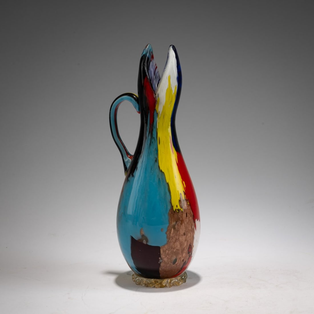 Dino Martens, 'Oriente' jug, 1954: <p>Model No. 5323. H. 23.3 cm. Execution: Aureliano Toso. Cased glass, colorless with multicolored powder inclusions, wavy base ring with gold foil.