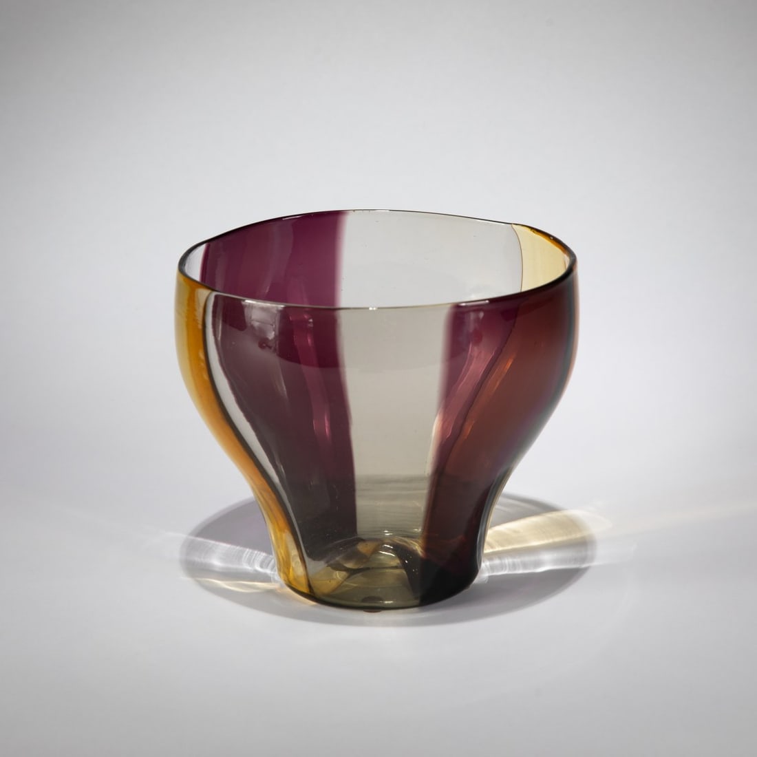 Fulvio Bianconi, 'A spicchi' vase, c. 1954-57: <p>Model no. 4896. H. 15,7 cm. Execution: Venini. Glass, colorless with vertical ribbons of violet, yellow and gray. Marked: venini murano ITALY (round acid stamp), maker's label.</p
