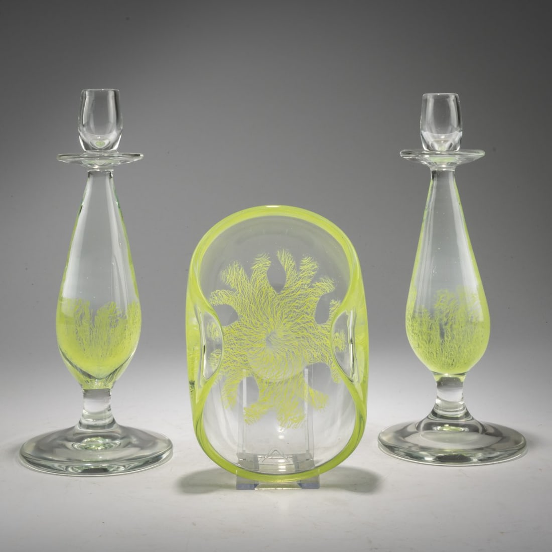 Archimede Seguso, Pair of candlesticks and a bowl, 'Merletto Frastagliato', 1955: <p>Candlesticks H. 26 cm; Bowl: H. 6 cm, L. 18 x 13 cm. Execution: Archimede Seguso. Cased glass, colorless, with partially melted bands featuring a 'Merletto' thread mesh in s