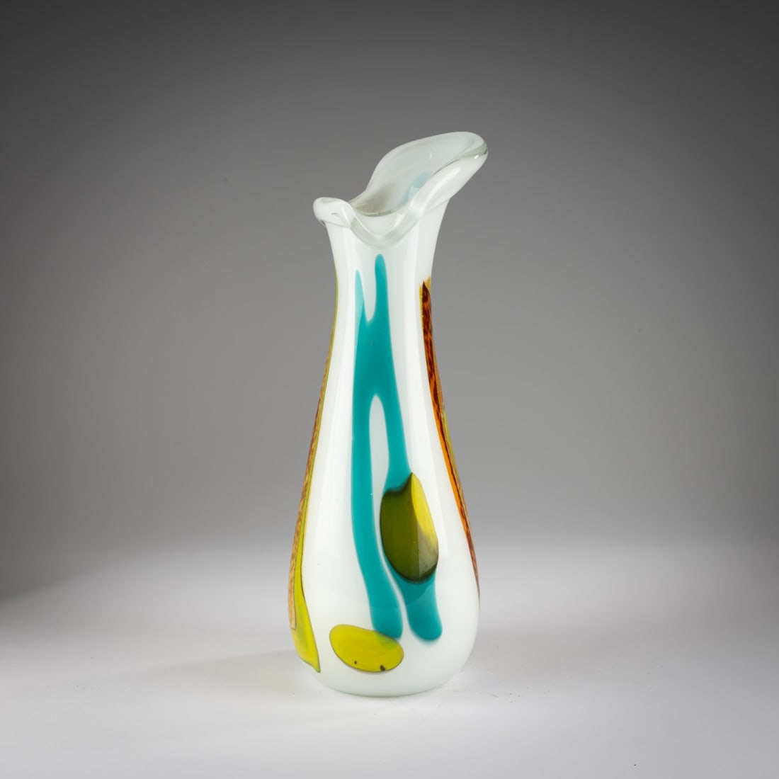 Anzolo Fuga, Vase, c. 1956: <p>H. 39.5 cm. Execution: A.Ve.M. Cased glass, colorless and white, with fused, partially overlapping bands in turquoise, yellow, and orange, as well as multicolored murrine and metal inclusions