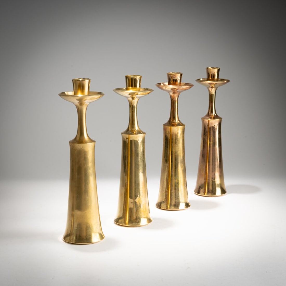 Jens Harald Quistgaard, Four candlesticks, 1930s (design): <p>H. 23.5 cm. <br />Dansk Designs, Copenhagen.<br />Brass. <br />Marked: Manufacturer's mark IHQ (stamped). </p>