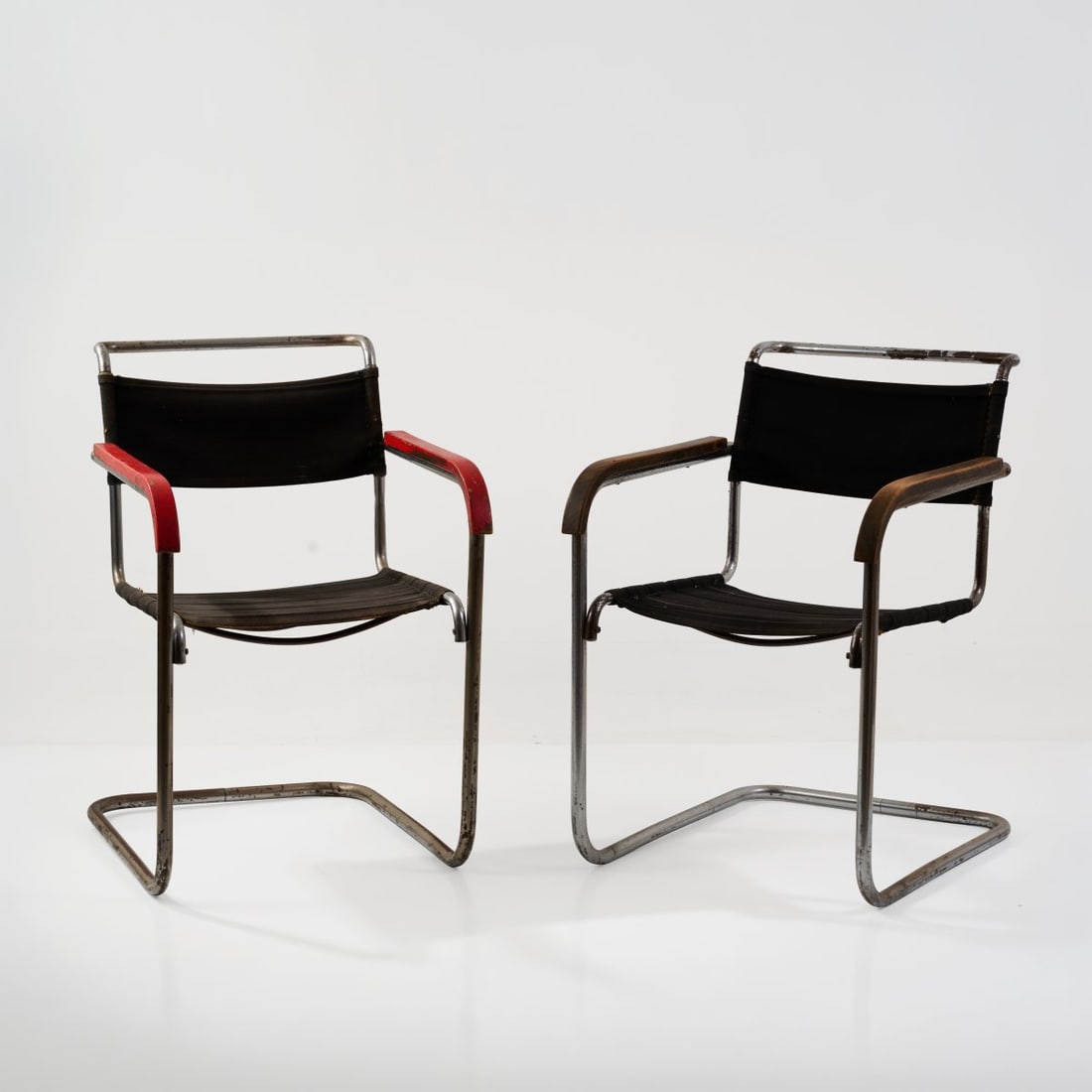 Marcel Breuer, Two cantilever chairs, 1930s (design): <p>H. 81.5 x 54.5 x 69 cm.<br />Thonet, Frankenberg (attributed)<br />Chrome-plated metal tube, wood, painted red and finished with a dark glaze, black fabric.</p>