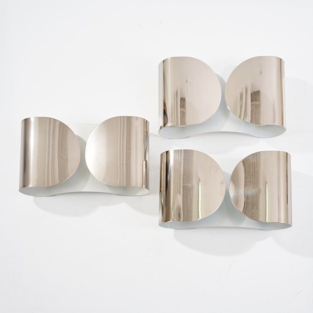 Tobia Scarpa , Three 'Foglio' wall lights, 1966 (design): <p>H. 21 x 37 x 10 cm.<br />Flos, Brescia.<br />Sheet metal, chrome-plated and painted white.</p><hr><p>Literature:</p><p>Bassi, La Luce Italiana,
