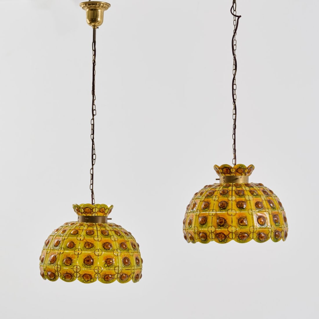 Felipe Delfinger's Feathers, Two ceiling lights, 1960s/1970s (design): <p>H. 24.5 cm, total: 88 cm, &Oslash; 34 cm. <br />Mexico (attributed).<br />Yellow, orange, and brown glass, sheet brass, metal wire.</p>