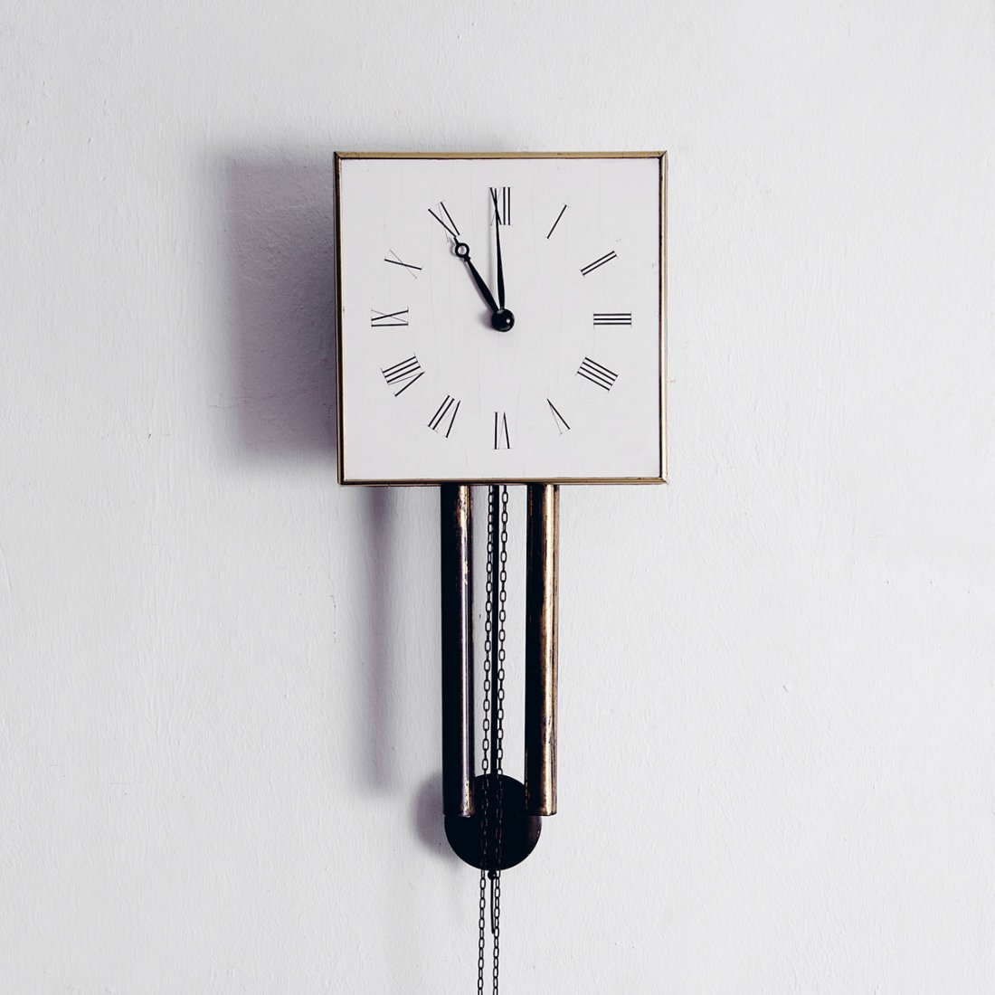 Wall clock: Heinrich Tessenow. Wall clock, 1910. H. 24.5 x 24.5 x 11.5 cm. Made by Deutsche Werkst_tten, Dresden-Hellerau. Wood, painted white, black roman numerals, brass frame.