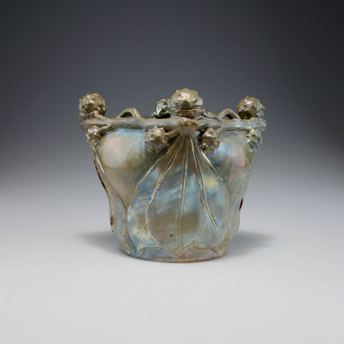 Vilmos Zsolnay, Pecs. Vase with chestnut, c1900. H.: Vilmos Zsolnay, Pecs. Vase with chestnut, c1900. H. 18.3 cm; 18.3 x 18.3 cm. Faience, reliefed pattern with chestnuts, green eosin glaze. Marked: Seal ZSOLNAY PECS, 3699, 36, 0.