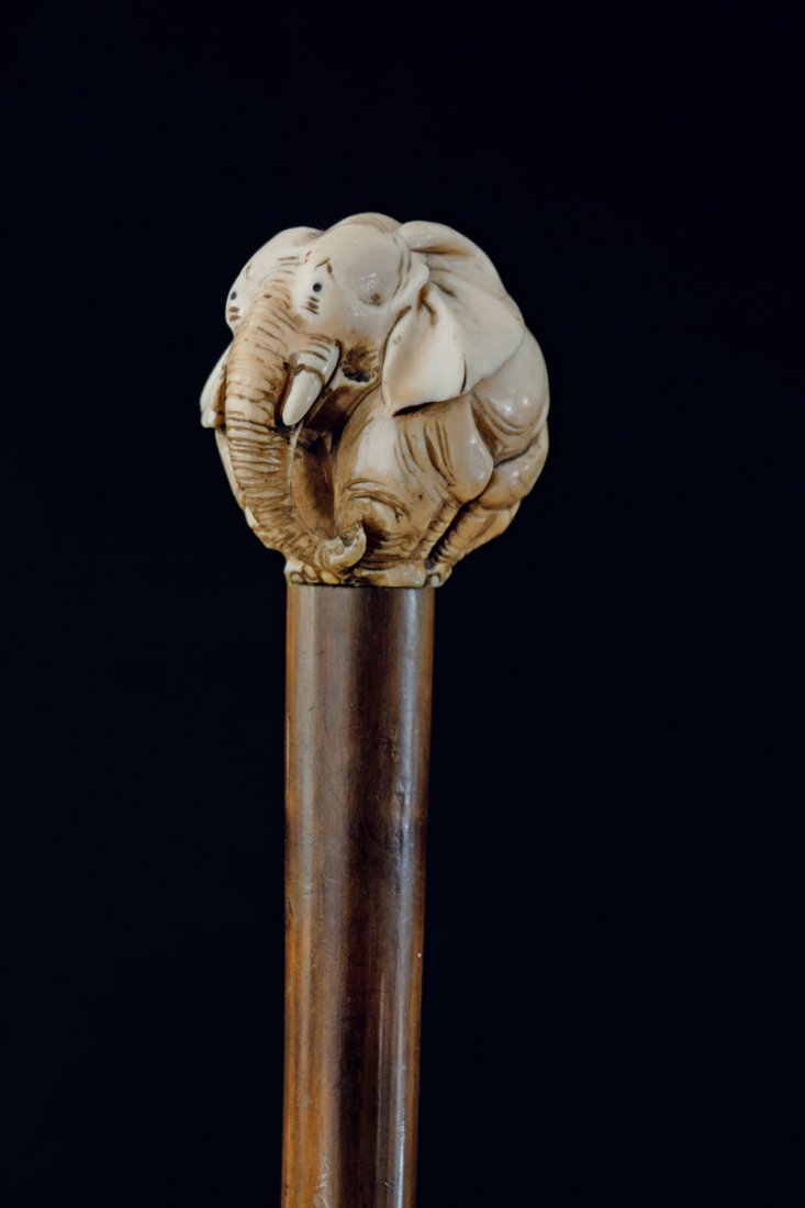 Japanese Netsuke carver. Walking stick with round: Japanese Netsuke carver. Walking stick with round elephant. Carved ivory, part tinted. L. 85.3 cm; handle: H. 4.8 x 4.5 x 4.5 cm.