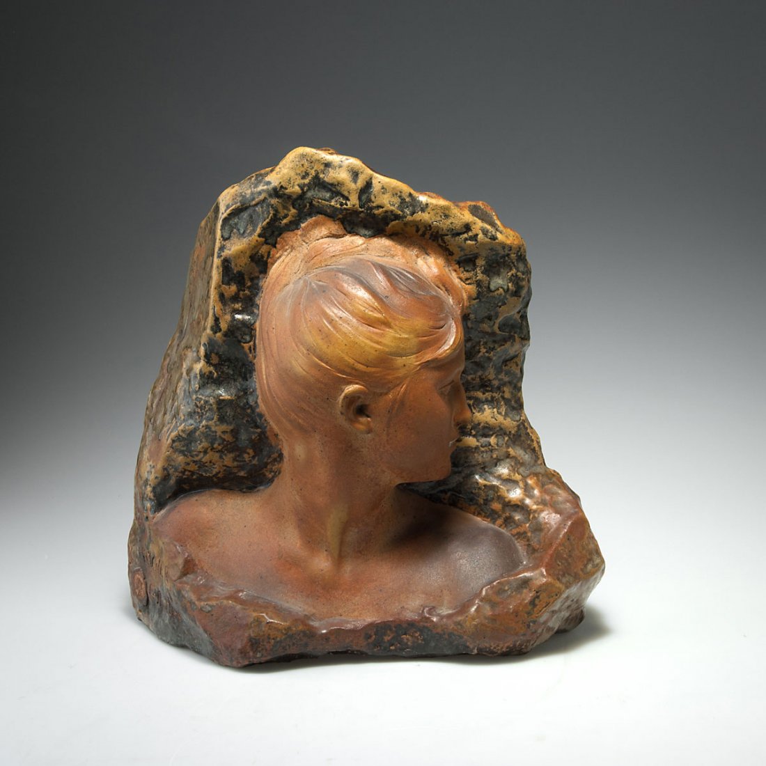 Alfred Boucher. Bust of a young woman, c1905. H. 36 cm.: Alfred Boucher. Bust of a young woman, c1905. H. 36 cm. Made by Emile Muller, Ivry. Stoneware, glazed matt, yellow, brown and anthracite grey, mimicking bronze with patina. Marked: BOUCHER, E. Muller,