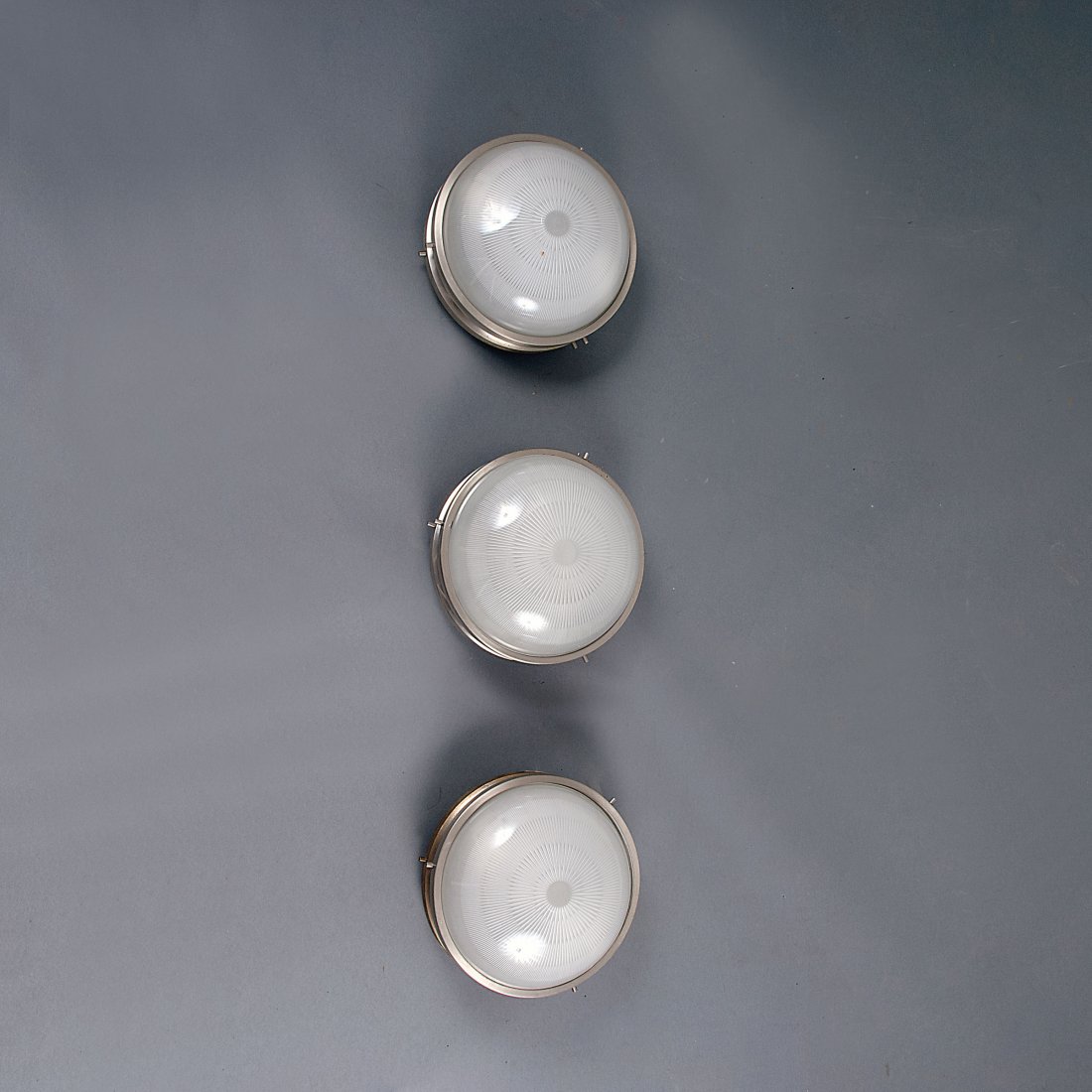Sergio Mazza. Three 'Sigma' sconces, 1960. H. 16 cm; D.: Sergio Mazza. Three 'Sigma' sconces, 1960. H. 16 cm; D. 26 cm. Made by Artemide, Milan. Nickel-plated brass, moulded glass.