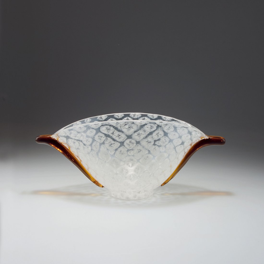 Bowl: Loetz Wwe., Klostermuehle. Bowl, c1935. H. 13.8 cm; L. 32.5 cm. Clear glass, white rhomb pattern, amber handles. Marked: made in Czecho-Slovakia.