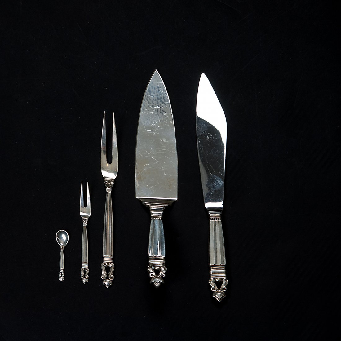 Five 'Konge - Acorn' serving pieces: Johan Rohde. 'Konge - Acorn' cake server, cake knife, two meat forks and salt spoon, 1915. Five pieces. Cake server, L. 26.5 cm; cake knife, L. 26.5 cm; 2 meat forks L. 11.8-20 cm; salt spoon, L. 6 cm