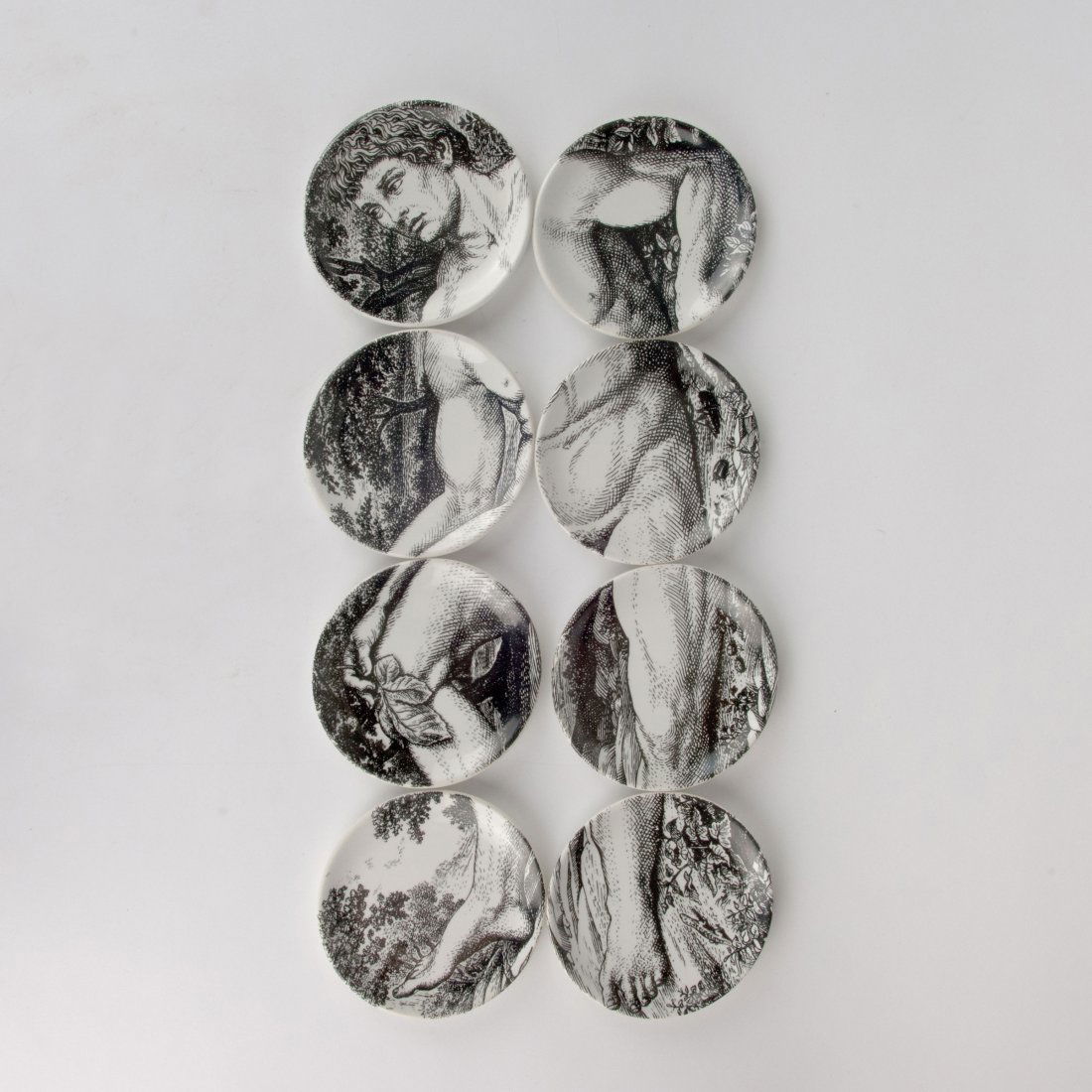 Piero Fornasetti. Eight 'Adam' saucers, c1965. D. 10.5: Piero Fornasetti. Eight 'Adam' saucers, c1965. D. 10.5 cm. Made by Fornasetti, Milan. Porcelain, white, glazed, black and white lithograph. Marked: ADAMO, ADAMO ED EVA, c PIERO FORNASETTI 1965, MADE I