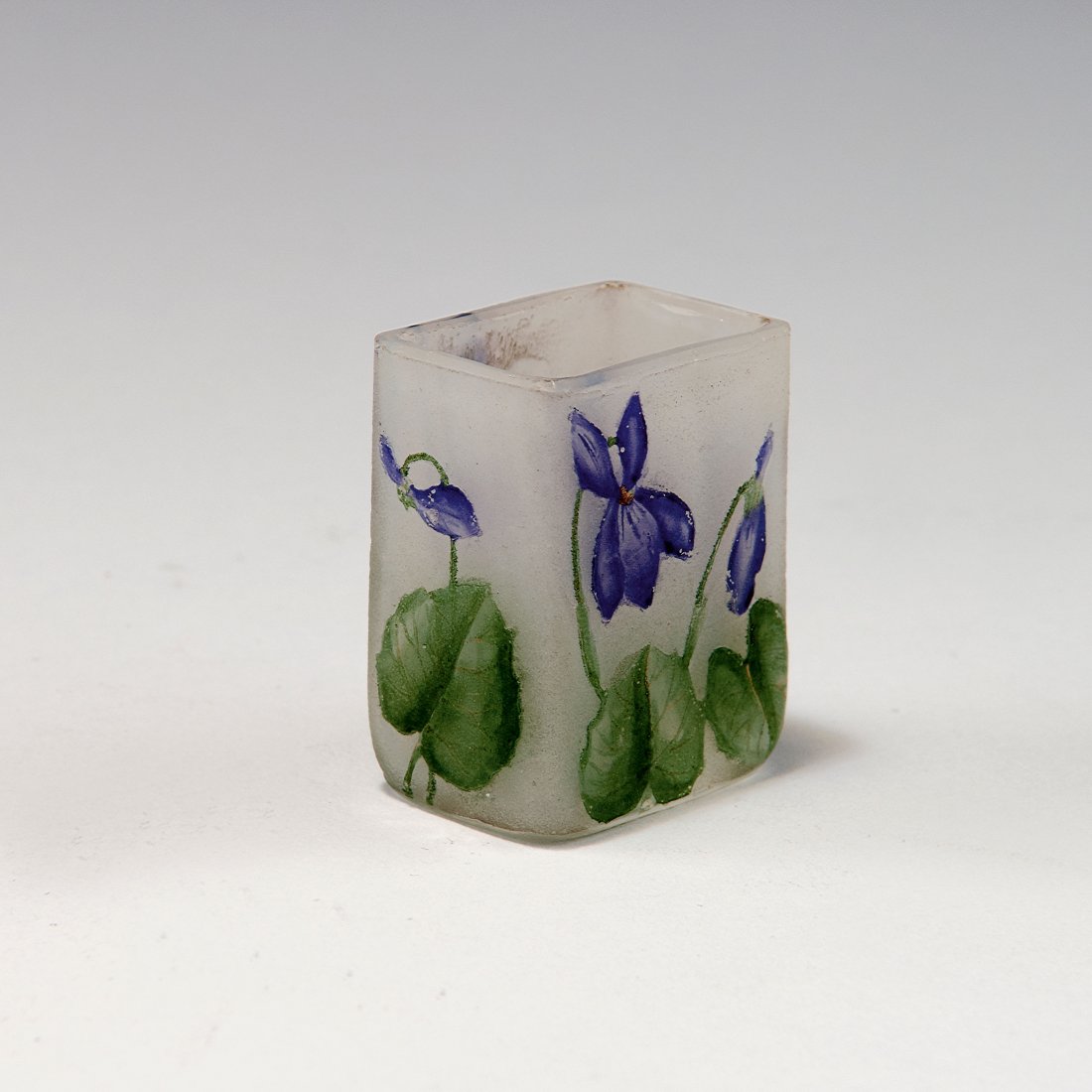 Miniature 'Violettes' vase, c1910: Daum Freres, Nancy. Miniature 'Violettes' vase, c1910. H. 3.8 cm. Cased glass, clear, milk white powder inclusions. Etched and enamelled pattern with violets. Signed: Daum Nancy, cross of Lorraine.