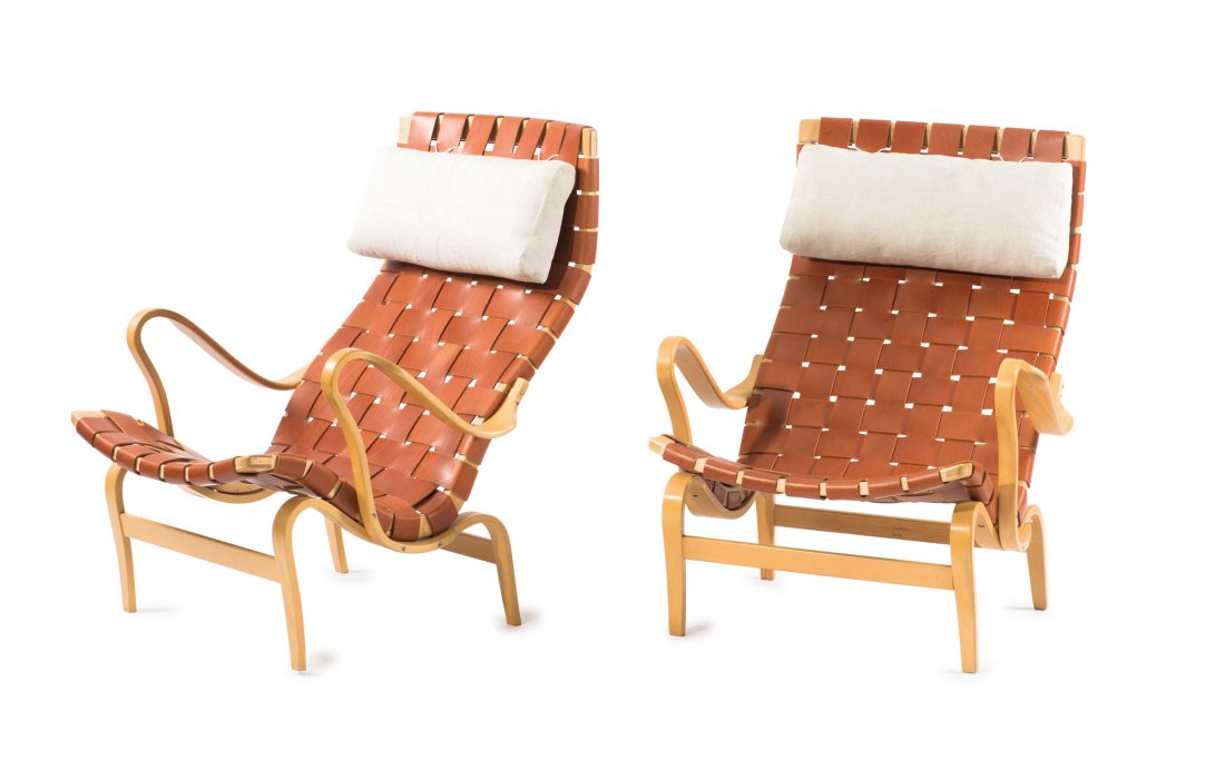Two 'Pernilla' lounge chairs, c1934: Bruno Mathsson. Two 'Pernilla' armchairs, c1934. H. 97 x 76.5 x 91 cm. Made by DUX, Trelleborg. Birch, birch plywood, auburn leather straps. Marked with branded manufacturer's label.