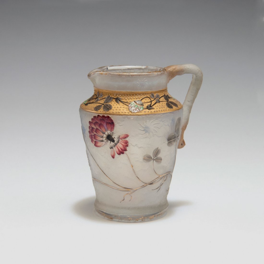 Small 'Trefles' jug, 1895: Daum Freres, Nancy. Small 'Trefles' jug, 1895. H. 5.7 cm. Cased glass, opal white and clear, etched and enamelled. Clover. Gilded. Signed: Daum Nancy, cross of Lorraine.