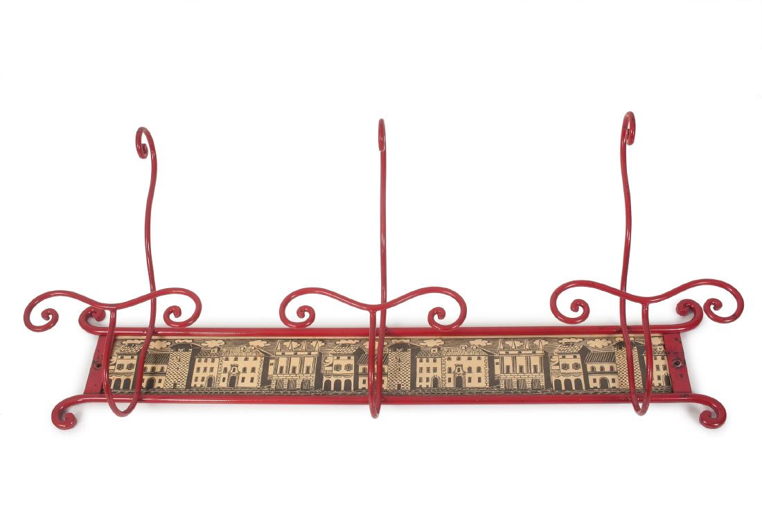 'Casette' coat rack, 1960s: Piero Fornasetti. 'Casette' coat rack, 1960s. H. 48 x 112 x 27.5 cm. Made by Fornasetti, Milan, 1960s. Steel, painted red, chipboard, with reproduction of an antique skyline. Marked: DA PORTABITI.
