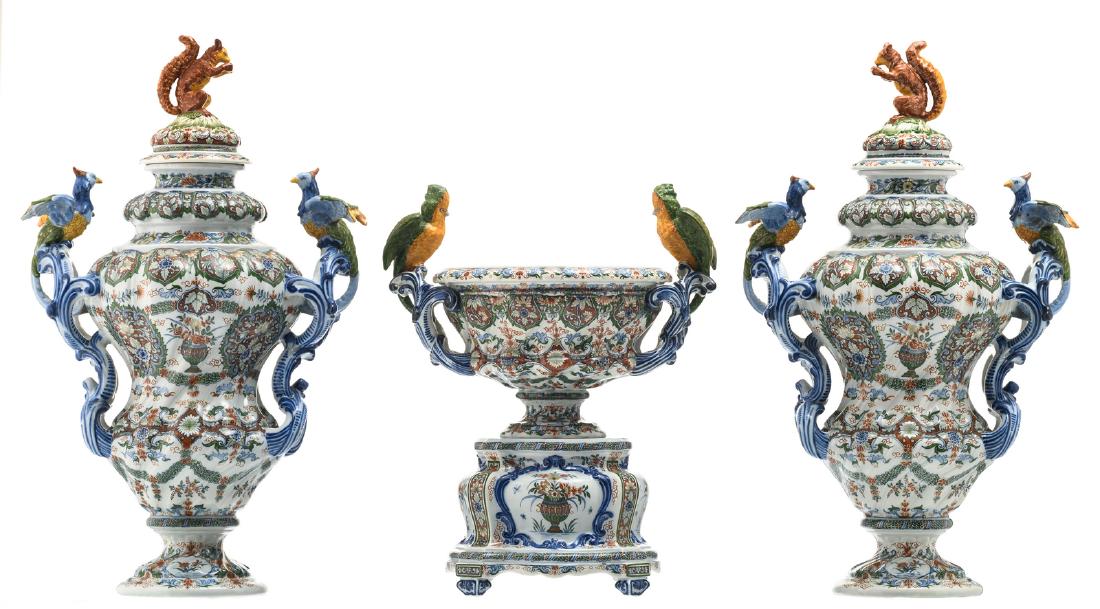 An imposing polychrome high fire decorated earthenware: An imposing polychrome high fire decorated earthenware three-part garniture, the grips of all items relief decorated whether with various birds, whether with squirrels, marked with an indecipherable m