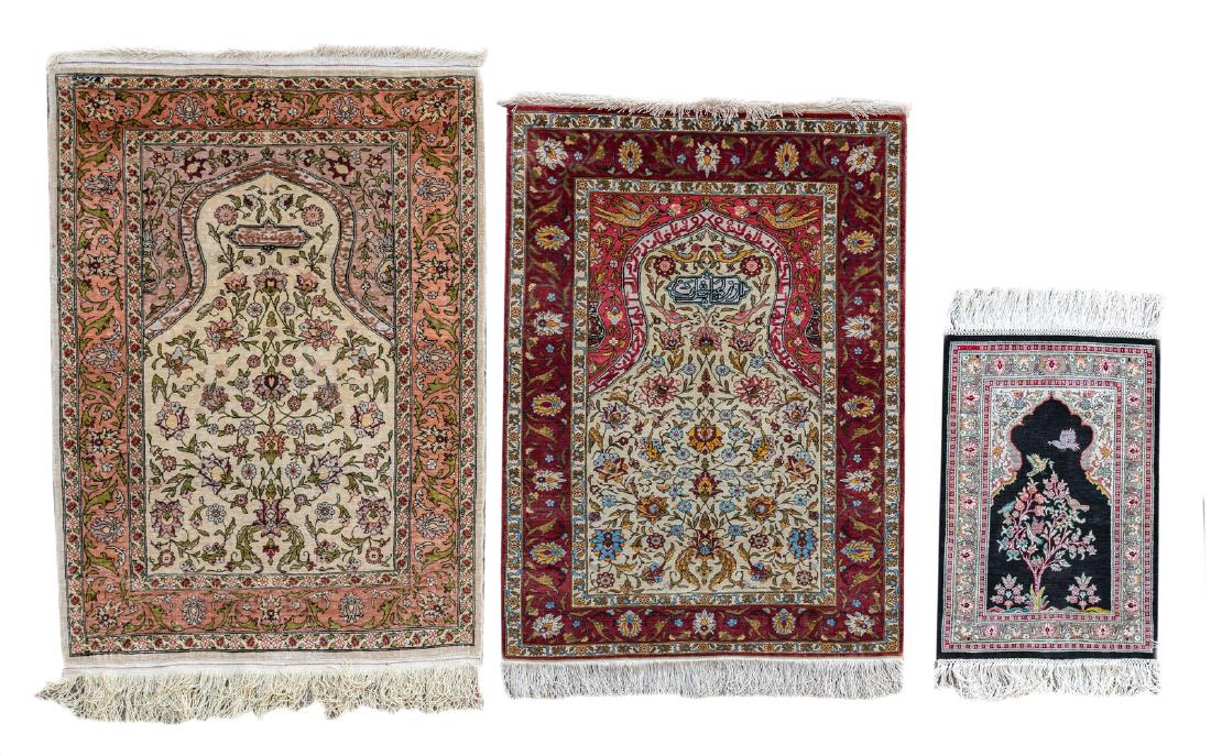 Two Oriental prayer rugs with floral motifs, birds and: Two Oriental prayer rugs with floral motifs, birds and calligraphic inscriptions, Hereke, silk and silver thread; added a ditto carpet, 37 x 54 - 63 x 98 and 65 x 97 cm