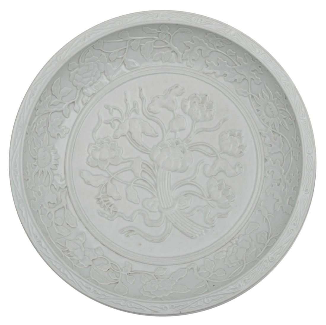 A Chinese floral relief decorated white glazed charger, (1 of 7)