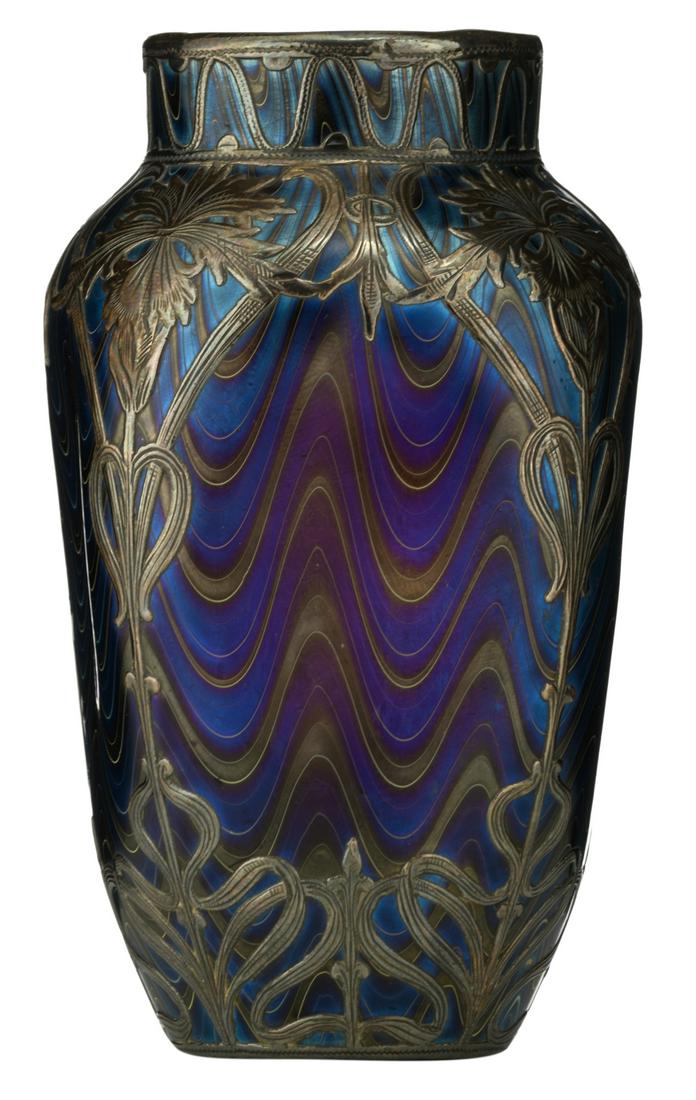 A fine Art Nouveau iridescent glass vase with a silver: A fine Art Nouveau iridescent glass vase with a silver floral relief overlay decoration, in the manner of Loetz, Austria, circa 1900, no visible hallmarks but tested on silver purity, H 10,9 cm