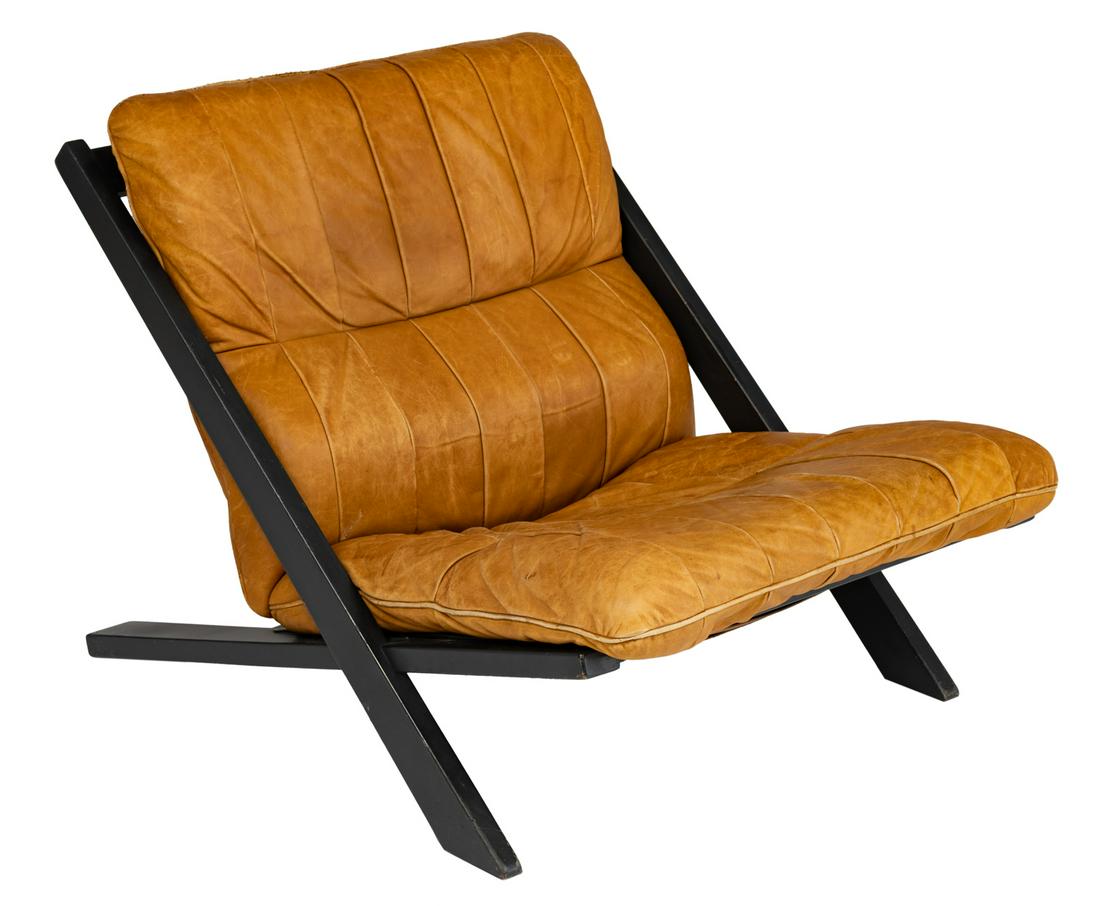 A black-painted wooden lounge chair with tan leather: A black-painted wooden lounge chair with tan leather upholstery, design by Ueli Berger for De Sede, the '80s, H 67 - W 71 cm