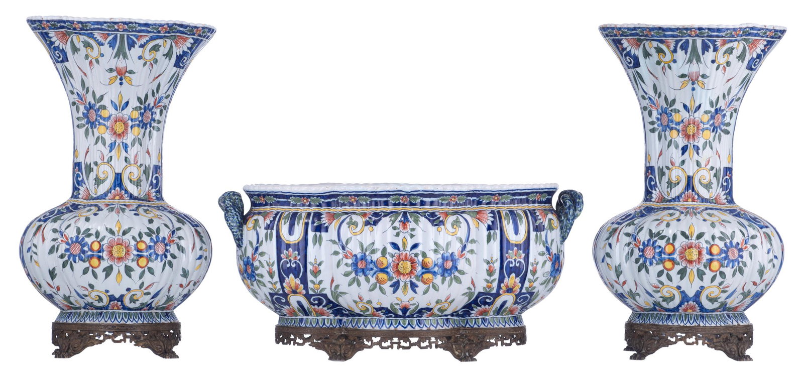 A charming three-piece DÃ¨svres earthenware garniture,: A charming three-piece DÃ¨svres earthenware garniture, polychrome decorated with flower branches, all three pieces with lobed bodies and mounted on gilt brass stands, the center-piece with braided h