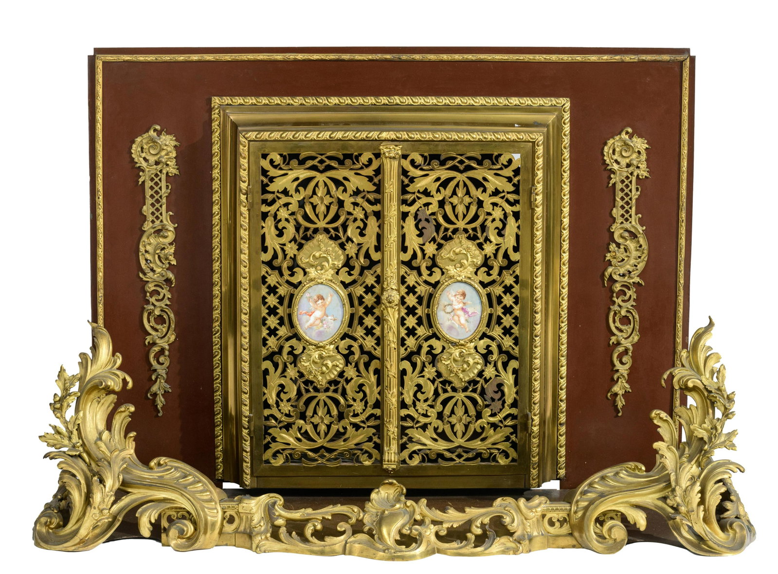 A fine Rococo style fireplace set, H 81,5 - W 125 cm: A fine Rococo style patinated and gilt bronze fireplace set, the central openworked doors decorated with two handpainted porcelain plaques depicting two cupids, probably Napoleon III period, H 81,5 - 