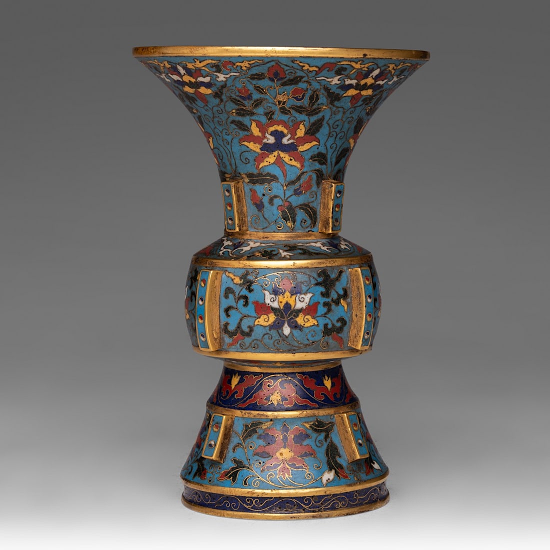 A Chinese cloisonne enamelled 'Lotus scroll' Gu vase, H 19 - dia 12,4 cm - weight about 1050 g: A Chinese cloisonne enamelled 'Lotus scroll' Gu vase, H 19 - dia 12,4 cm - weight about 1050 g A Chinese cloisonne enamelled 'Lotus scroll' Gu vase, all over decorated with lotus scrolls on a bright b
