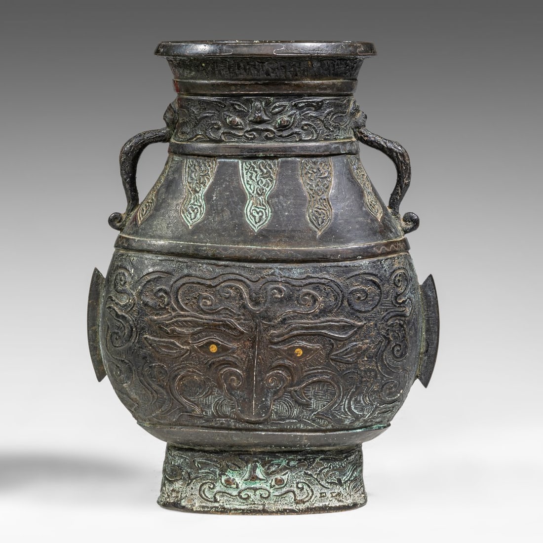 A Chinese archaistic bronze Hu vase with Taotie masks, 19thC/20thC, H 26 cm: A Chinese archaistic bronze Hu vase with Taotie masks, 19thC/20thC, H 26 cm A Chinese archaistic bronze Hu vase with Taotie masks, the body cast with a Taotie mask on each side, details heightened by 