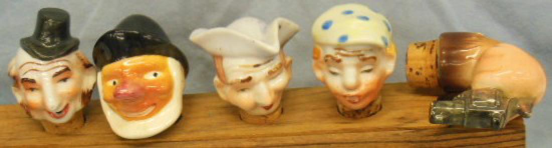 4 Porcelain Head & Other Bottle Stoppers: (4) Porcelain head (pourer) bottle stoppers including man with tri-painted hat, man with spotted cap, old salt and man with top hat, all hand painted 2 1/2" - 3", plus (1) hand with pistol from bottle
