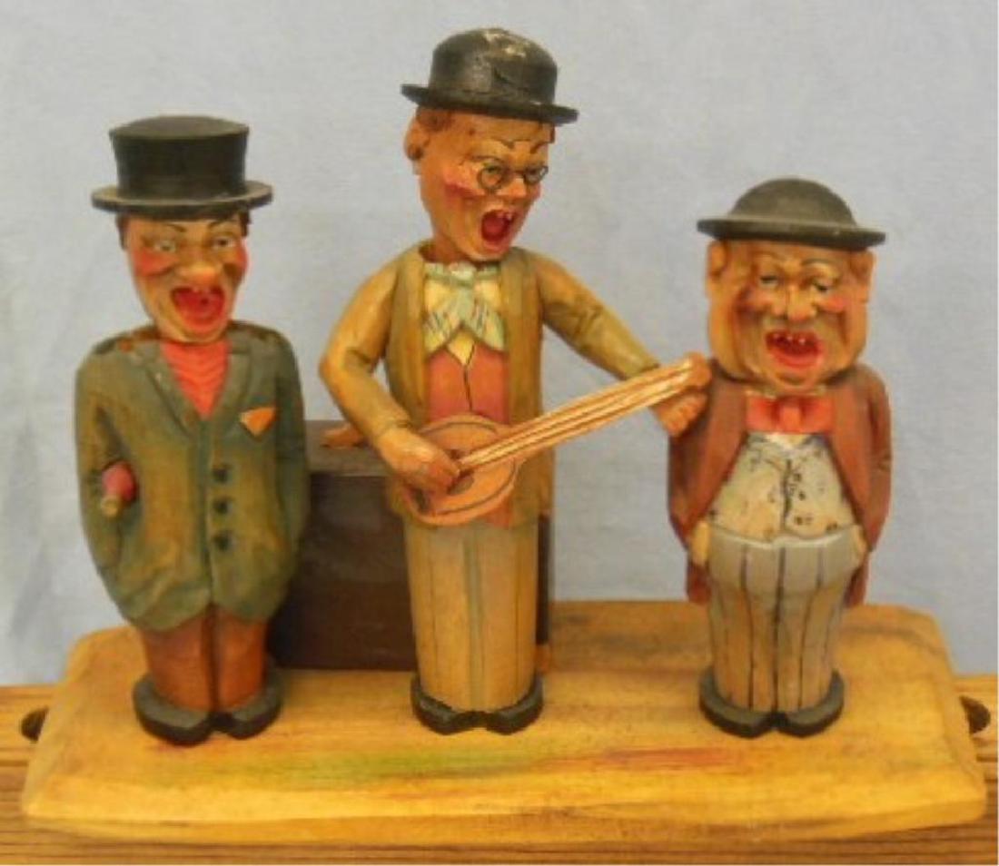 Anri ? Carved Figural Bar Set: Anri ? Carved Figural Bar Set , musical, three piece carved figures on wood base with suit cage music box in rear, marked made in Italy on bottom with paper label song title "Noch em Rage Schint d'Sun