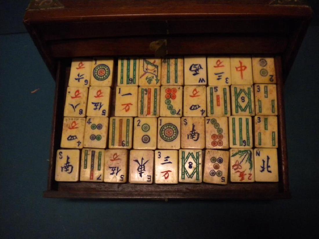 Chinese Cased Mahjong Set: Chinese Cased Mahjong Set, hardwood case with brass handles and corner mounts, bone and bamboo tiles and accessories, early 20th C. 9 1/2" x 6 1/4" x 6 1/2". CONDITION: Scratches on case, missing a fr