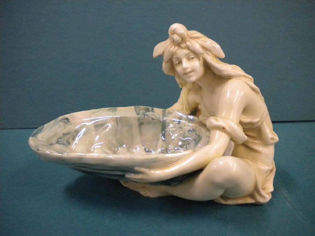 Royal Dux Art Nouveau Soap Dish: Royal Dux Art Nouveau soap dish, features a seated maiden holding a shell dish. early 20th c, 6 3/4" x 5" x 4 1/2". CONDITION: Very good.