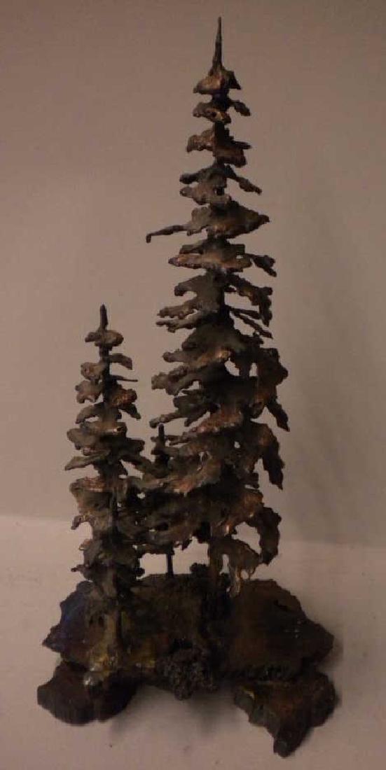 Crnich Signed Iron Sculpture: Crnich Signed Iron Sculpture, depicts 4 evergreen trees on fauna and rock formations, copper finish, dated 1999, 13 1/2" x 7" x 6". CONDITION: Very good, no issues identified.