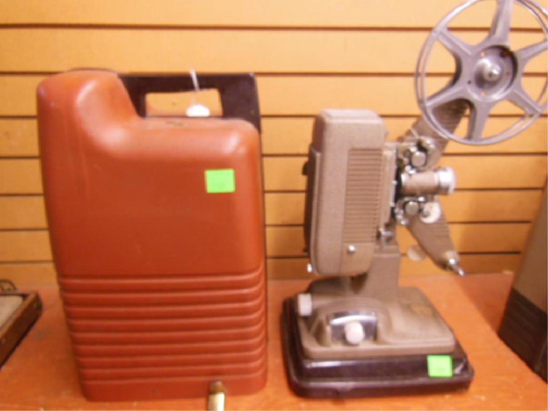 Vintage Revere 16mm Projector: Vintage Revere 16mm Projector , model 48 on base with projector cover, cord under projector, with one take up reel, untested, 19"h. CONDITION: Overall good, residue on back plastic knob.