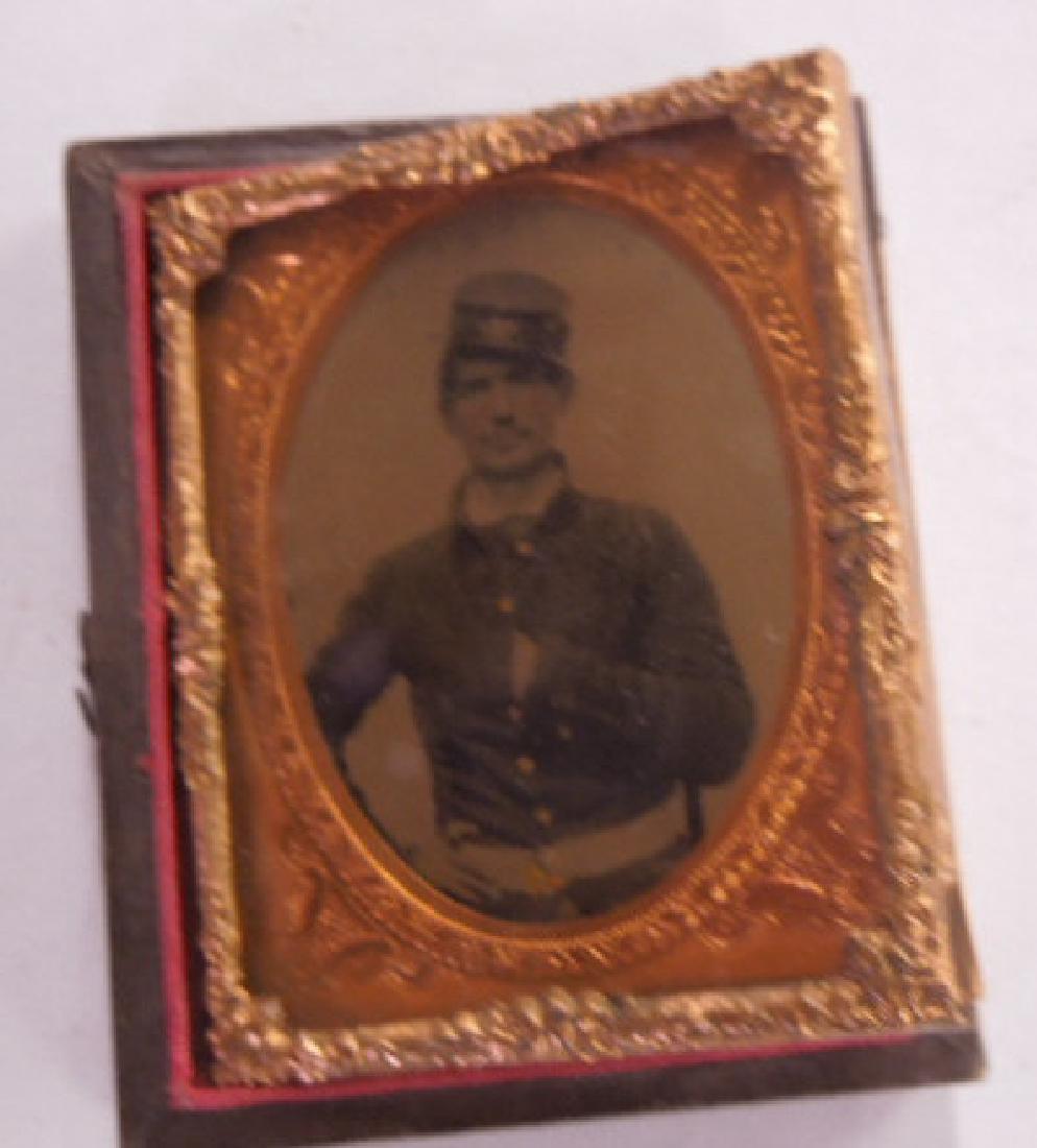 19th C.Civil War Soldier Ambrotype: 19th C. Civil War Soldier Ambrotype 1/9 size, featuring portrait, soldier with hand in uniform, under with metal matt in gold foil frame. CONDITION: Some wear from age.
