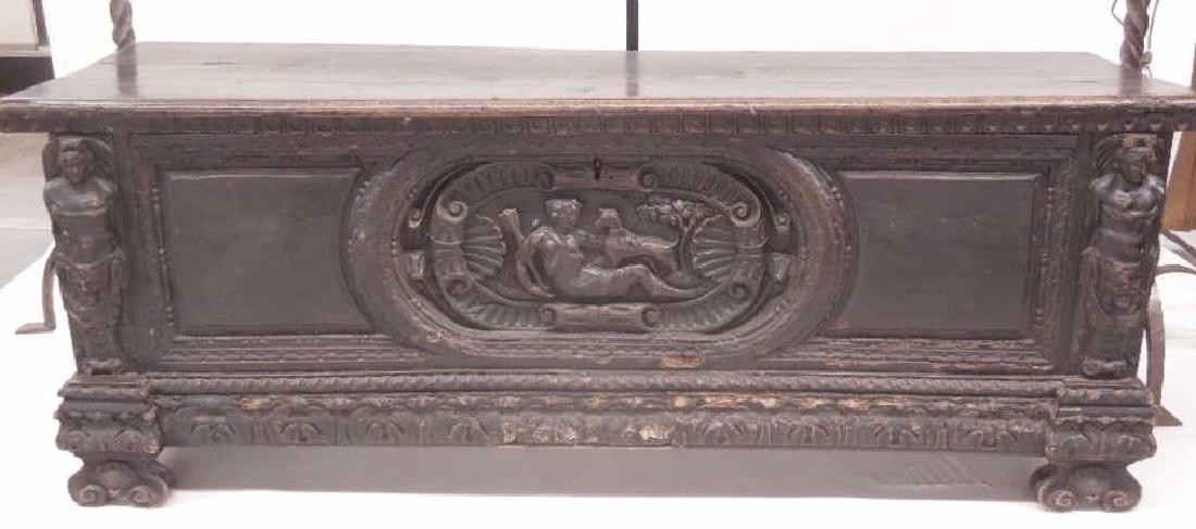 18th C. Italian Cassone: 18th C. Italian Cassone, walnut, molded lift lid with hammered iron hinges, front with a deep relief carved cartouche of a reclining maiden with dog, flanking on chest ends are some nude male figures,
