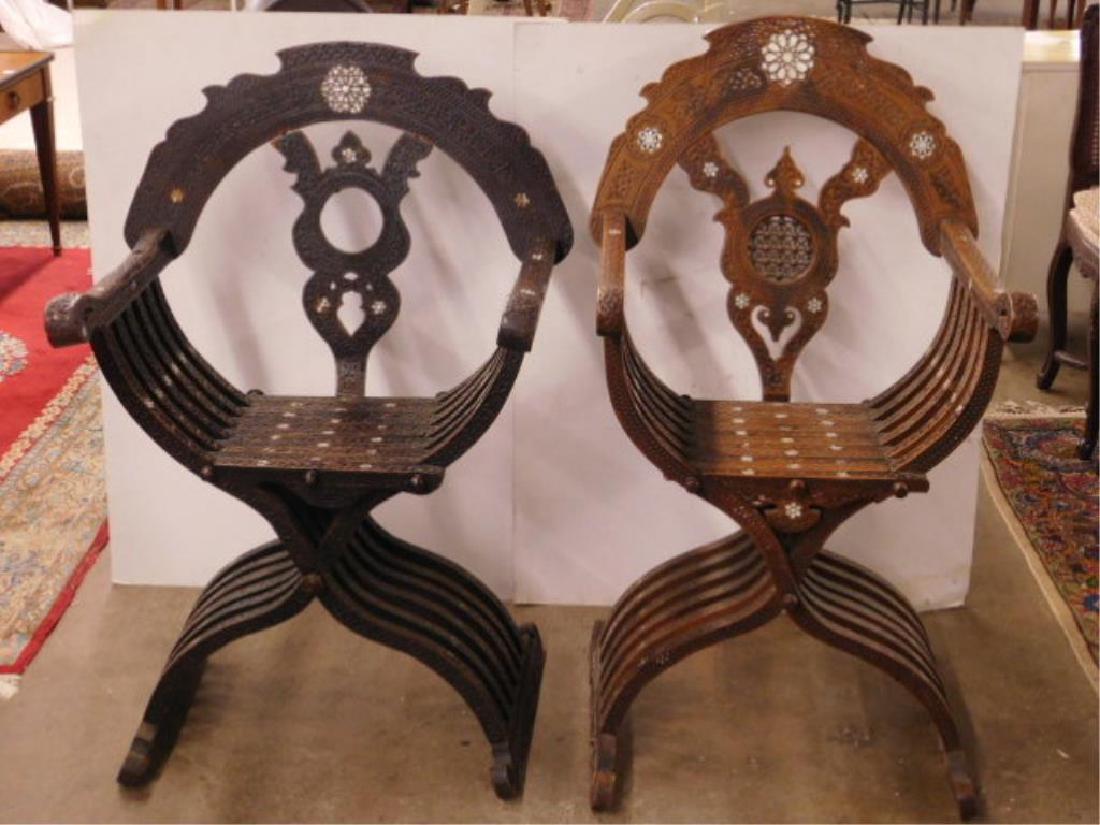 2 Savanorolla Arm Chairs: Two Savanorolla arm chairs in Moorish style overall relief carved hardwood with mother of pearl inlays, early 20th C. 41" h. CONDITION: Some mother of pearl inlays missing, one chair missing the ball 