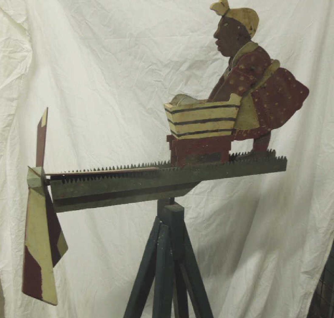 Whirligig on Stand: Whirligig on Stand, hand made and painted, depicts Aunt Jemima washing clothes in a tub, upon a splayed four leg platform, early 20th C, 64"h, 27"l. CONDITION: Paint crazing, wear to paint on base, on