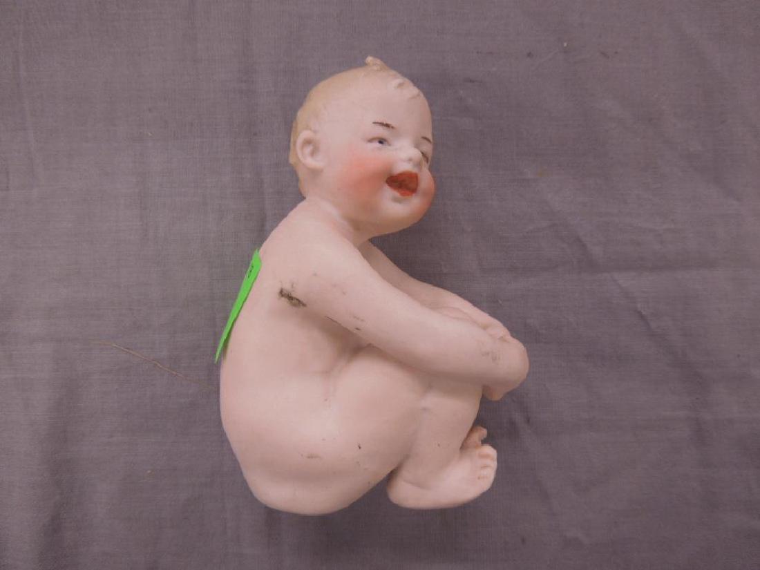 Small Bisque Piano Baby: Small Bisque Piano Baby, boy figure, nude, seated with arms around folded legs, hand painted face and hair, unmarked, 4 1/2". CONDITION: Black mark under right arm, minor marks, otherwise no issue.