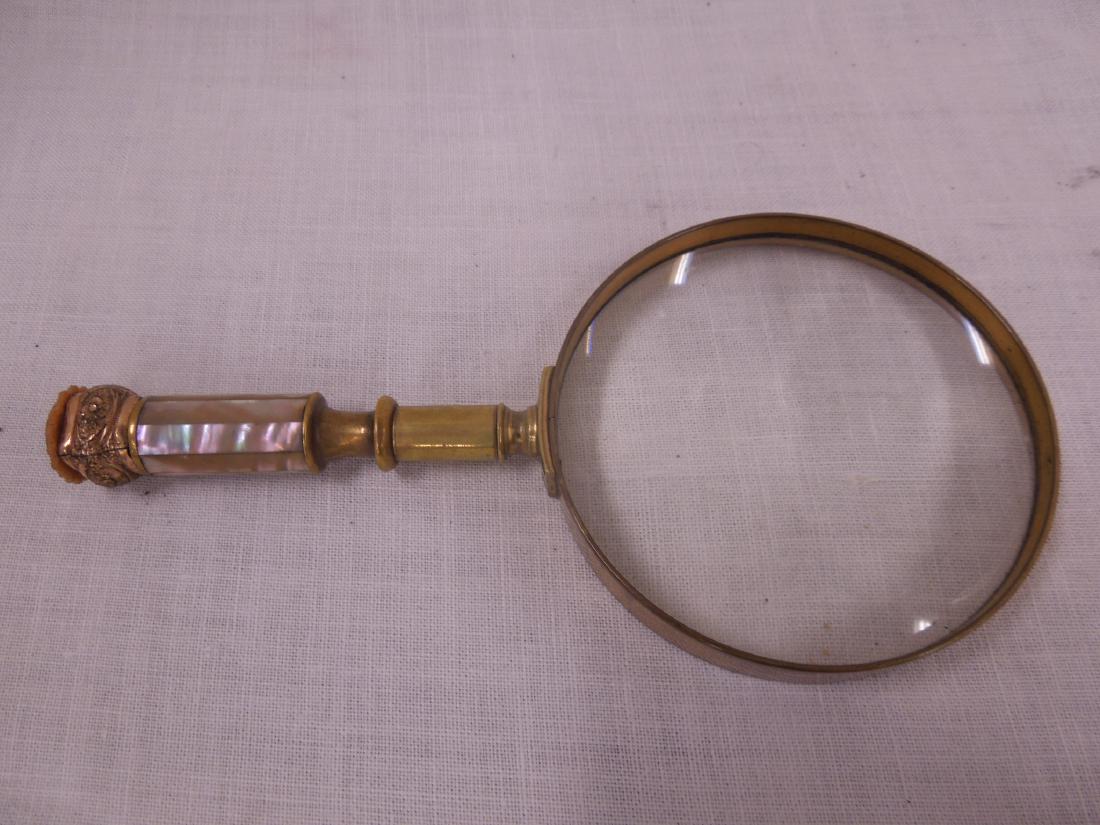 Vintage Magnifying Glass: Vintage magnifying glass, brass, 4 1/8" dia. lens with mother of pearl, brass, gold plated and carved nut handle, late 19th c. Condition; areas of tarnish, small edge chips on carved nut button