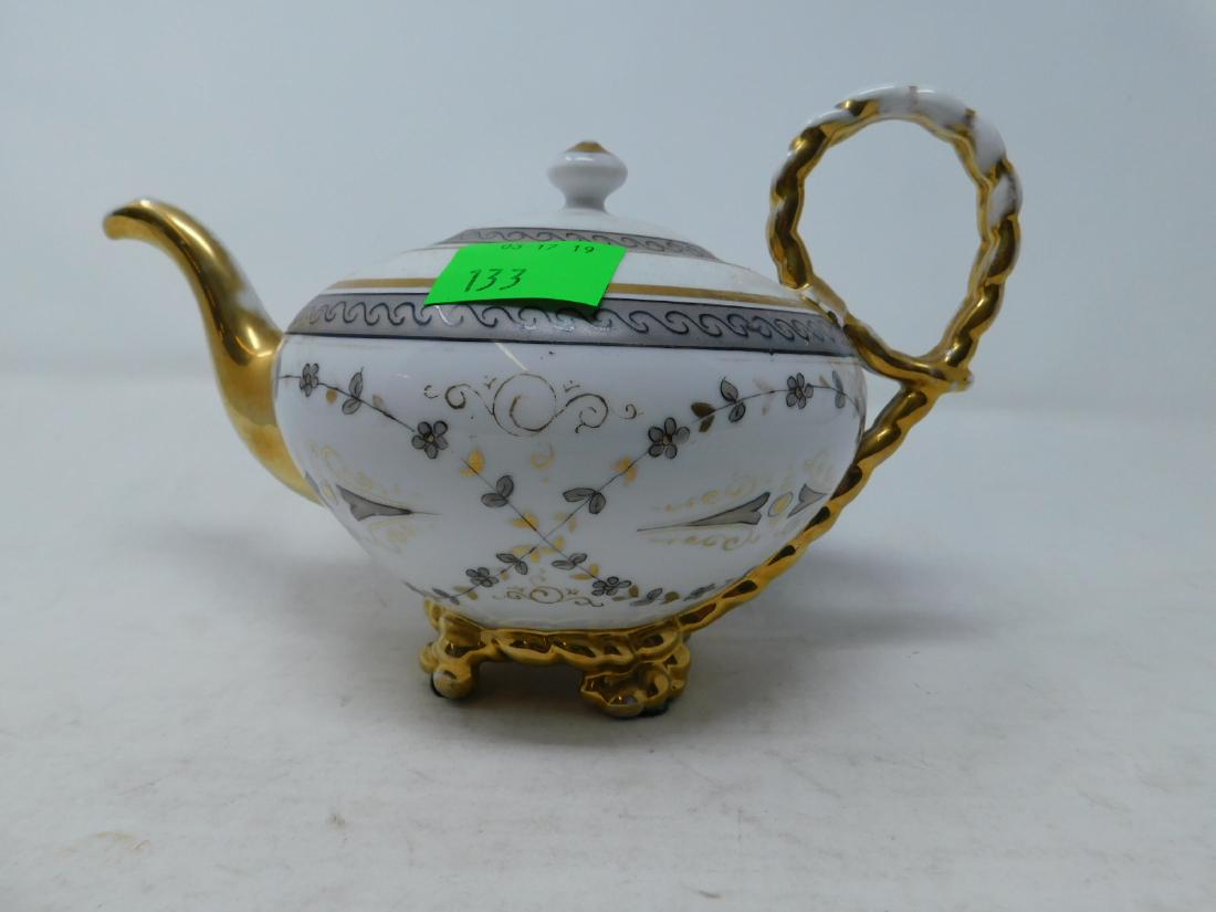 Antique Vieux Paris (Old) Porcelain Teapot: Antique Vieux Paris (Old) Porcelain Teapot: Unusual footed form with gilded rope-form handle, hand-painted en grisailles with small flowers. Mid-19th century. Provenance: Robert A Goldstein. Size: 8.7